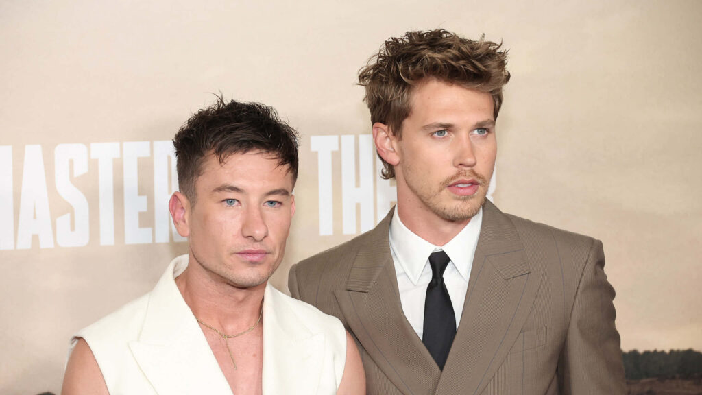 Barry Keoghan and Austin Butler in stylish suits posing at formal event with neutral backdrop wallpaper