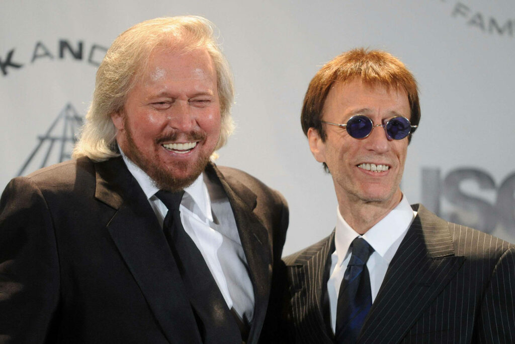 Barry and Robin Gibb of the Bee Gees smiling together in formal attire at an event classic wallpaper