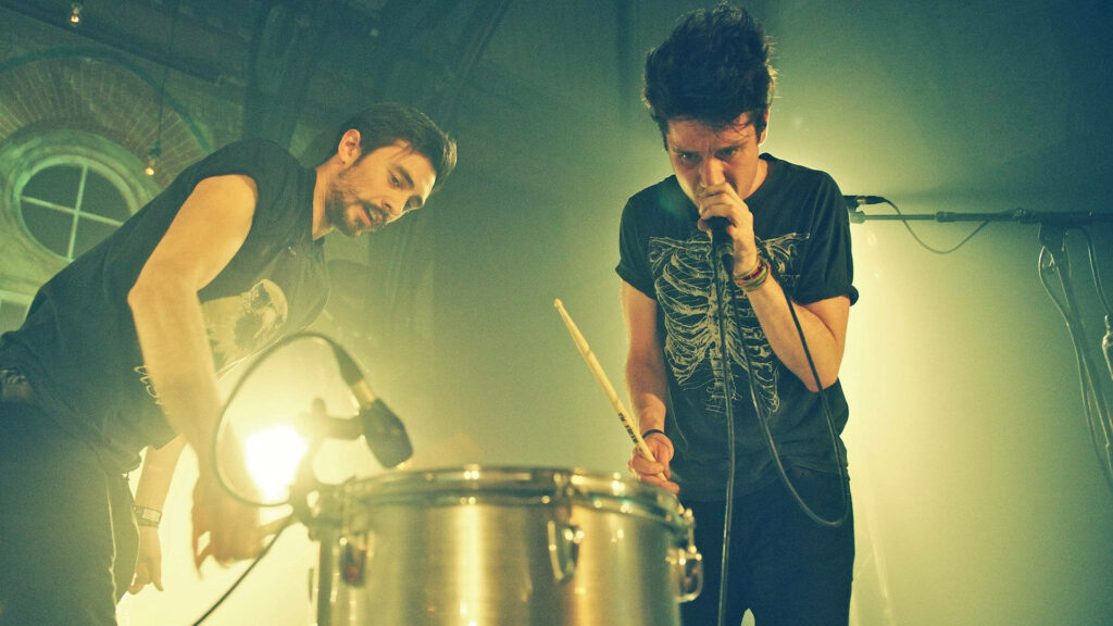 Bastille live concert wallpaper showing band performing on stage with dynamic lighting effects