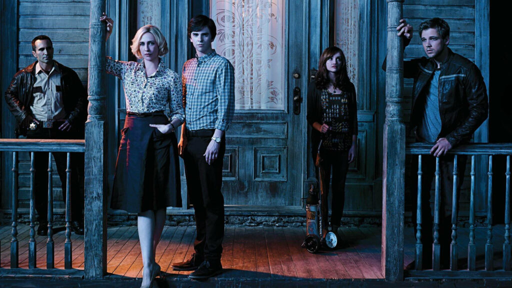 Bates Motel main characters standing by iconic door in tense mysterious thriller wallpaper background