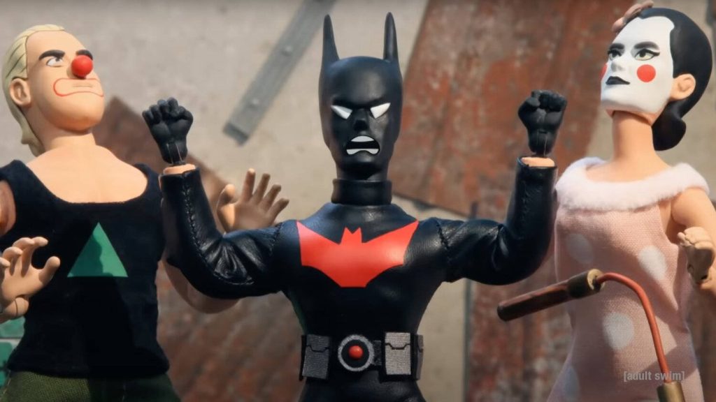 Robot Chicken stop-motion Batman Beyond figure with two clown-faced toys on gritty backdrop Wallpaper