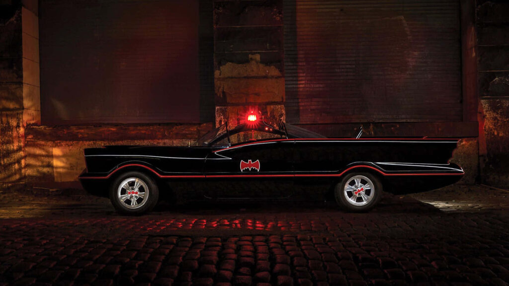 Menacingly Majestic: Batmobile Beast Unveiled in Black and Red Glory, Emblazoned with the Iconic Batman Logo and Striking Red Light Wallpaper