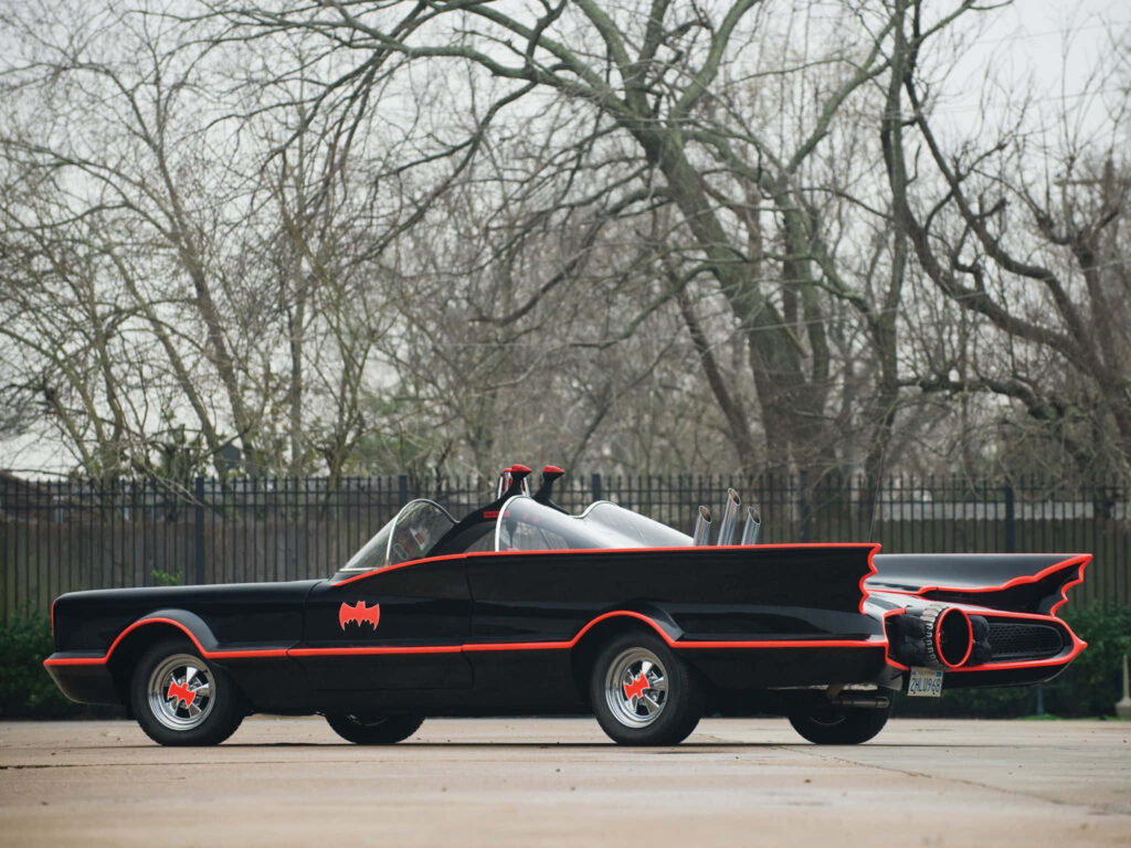 The Dark Knight's Menacing Batmobile Replica: Parked Amidst Barren Trees in a Striking Red and Black Design Wallpaper