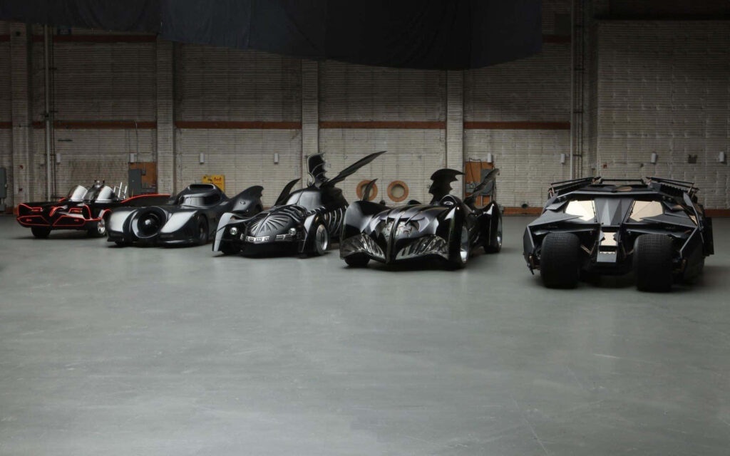 Fierce Fleet of Batman's Monstrous Rides, Ready for Action Against Grey Barrier Wallpaper