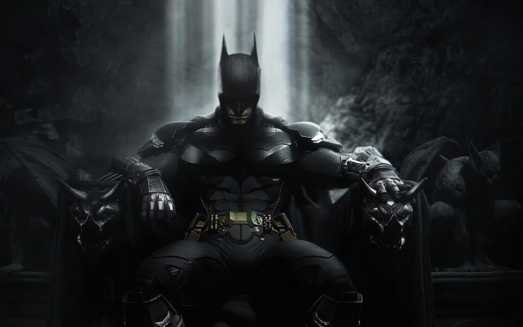 Batman in armored suit sits stoically in shadowy Batcave with dramatic waterfall background wallpaper