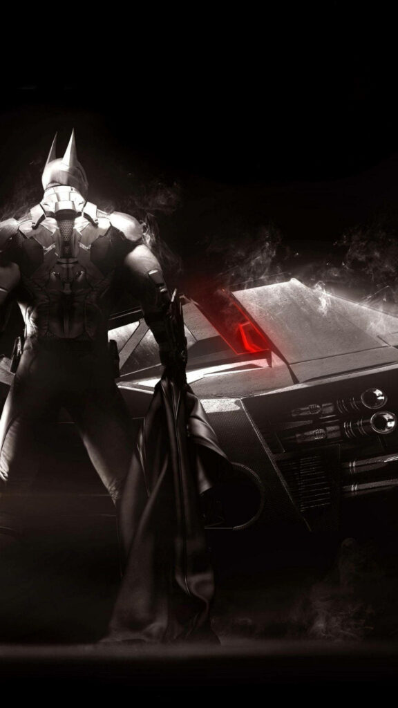 The Dark Knight Rises: Batman Strikes a Commanding Pose beside his Iconic Batmobile Wallpaper