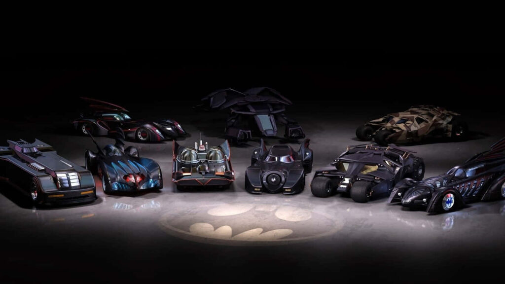 Batmobile Parade: A Dynamic Array of Models Illuminated by the Iconic Batman Logo Wallpaper