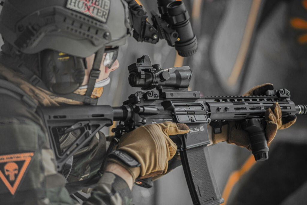 Tactical soldier aiming modern rifle in full combat gear with Zombie Hunter helmet patch wallpaper
