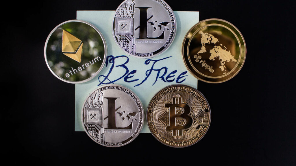 Cryptocurrency wallpaper with Bitcoin Ethereum Litecoin coins and Be Free text on dark background