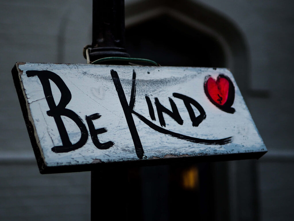 Hand-painted Be Kind sign with red heart on uplifting positive message wallpaper background