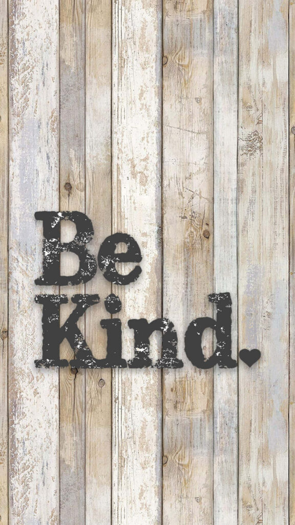 Be Kind inspirational message in bold distressed letters on rustic weathered wooden background Wallpaper