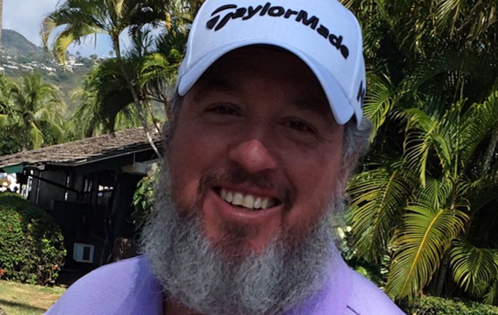 Bearded Boo Weekley smiling in TaylorMade cap outdoors with tropical palm trees and clear sky Wallpaper