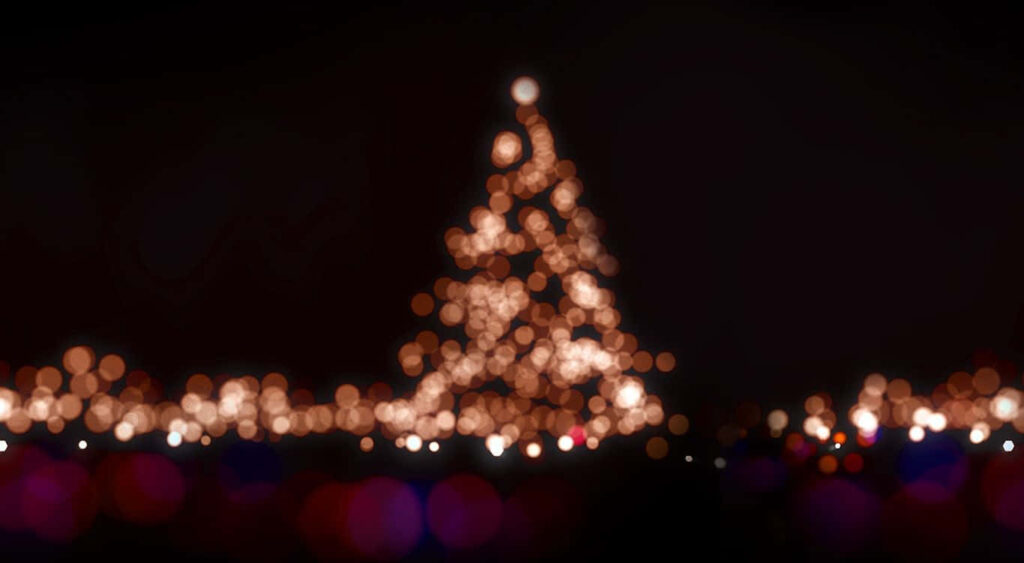 Enchanting Blurred Christmas Tree with Twinkling Lights on Dark Background Wallpaper