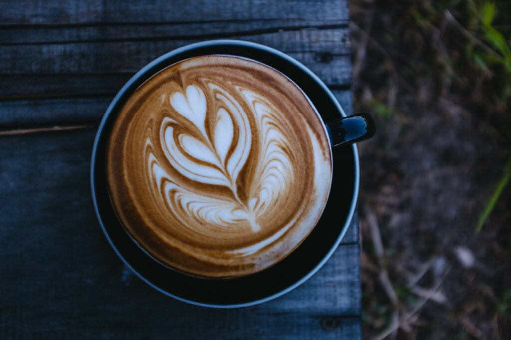 Stylish Cappuccino with Heart Latte Art on Rustic Wooden Wallpaper