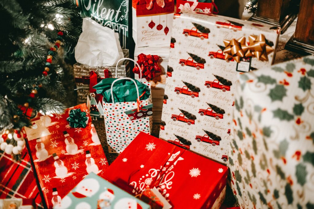 Festive Christmas Wallpaper: Gifts Under a Cheerful Tree Background