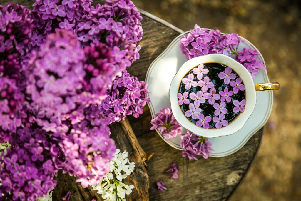 Chic Coffee Cup Wallpaper: Lilac Flowers on Rustic Wood Background