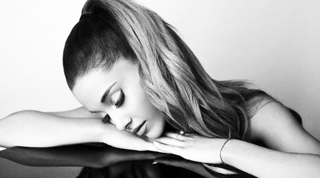 Ariana Grande monochrome wallpaper serene resting pose high ponytail soft dramatic lighting