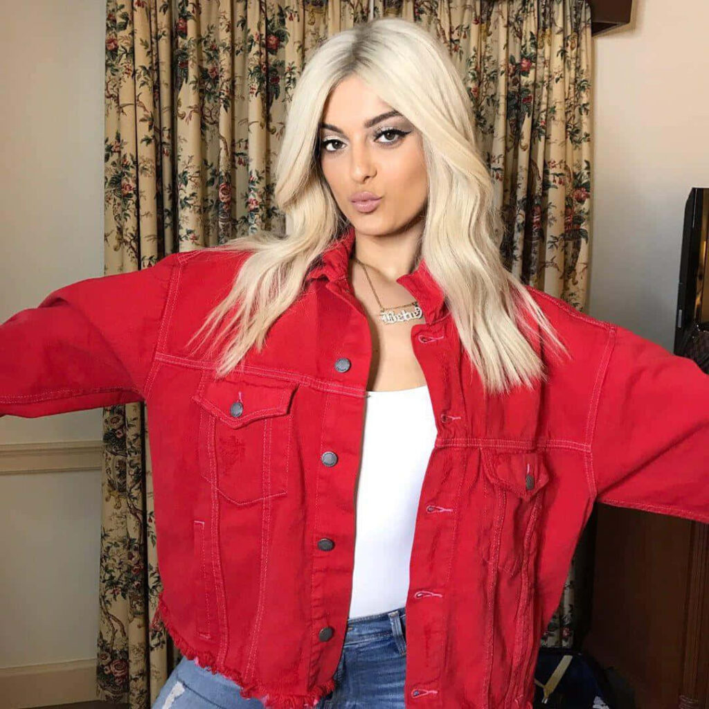 Bebe Rexha's Chic Red Jacket: Stylish Cozy Indoor Wallpaper