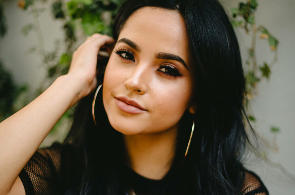 Becky G confident pose MEGA 96.3FM Party radiant makeup stylish hoop earrings natural background Wallpaper