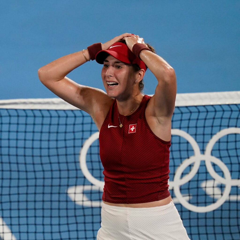 Belinda Bencic celebrates Olympic tennis victory with emotional expression and Olympic rings background Wallpaper