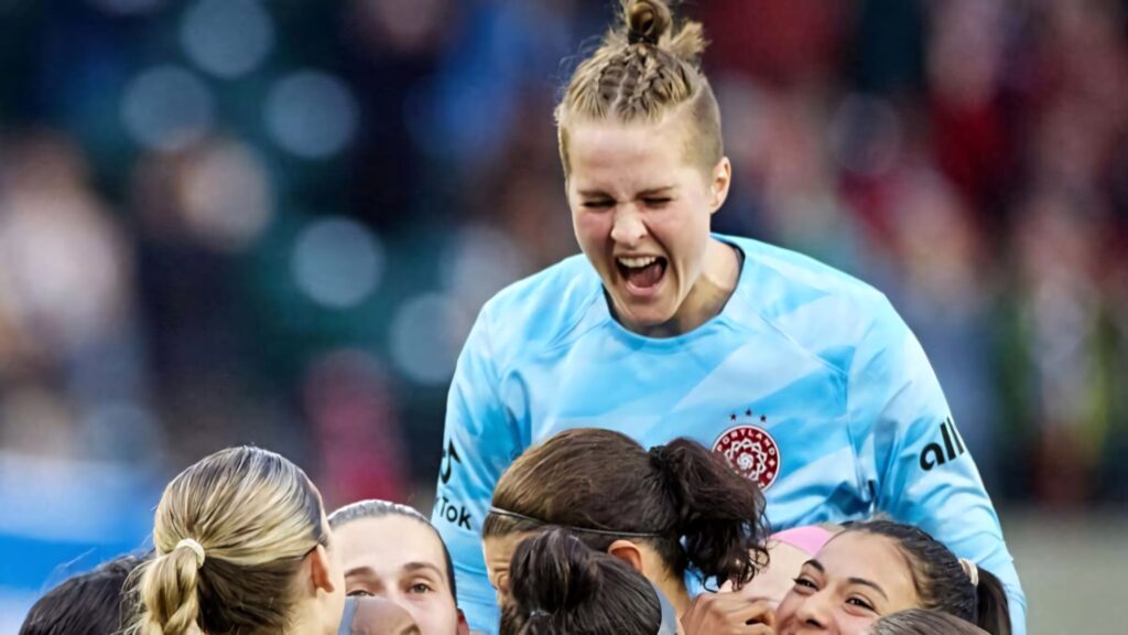 Bella Bixby lifted by teammates celebrating soccer victory unity excitement on field wallpaper