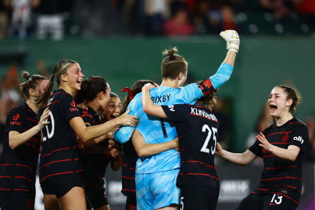 Bella Bixby and teammates celebrate soccer victory on field capturing unity and triumph moment Wallpaper