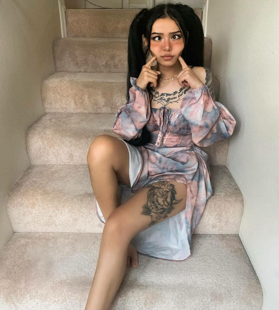 Bella Poarch Goofy Face Wallpaper: Pastel Dress & Tattoos on Stairs