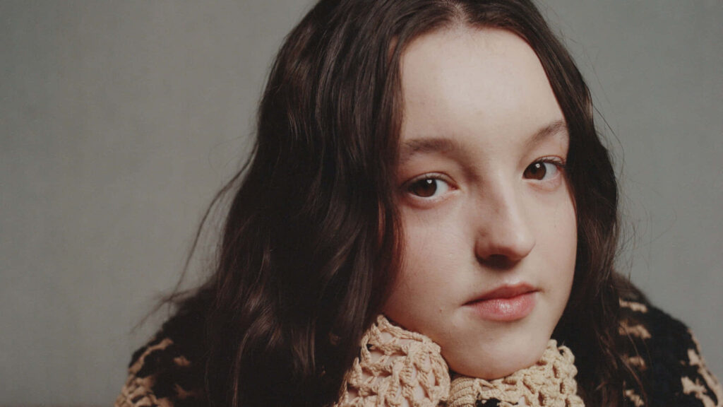 Close-up portrait of Bella Ramsey with soft expression and natural beauty on neutral background Wallpaper