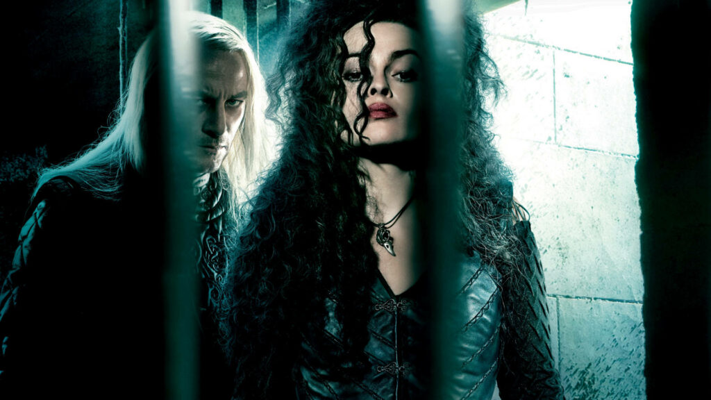 Bellatrix Lestrange fierce expression wild curly hair dark attire menacing pose dim background wallpaper