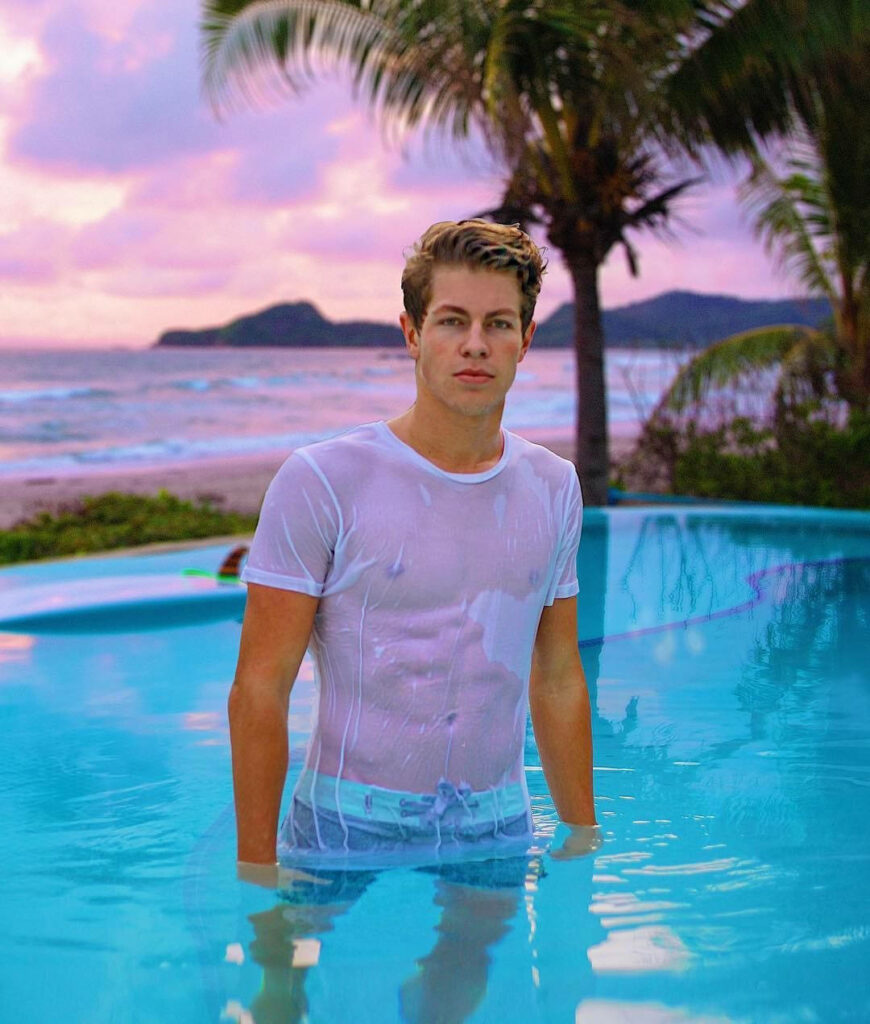 Ben Azelart in tropical resort pool at sunset with palm trees serene wallpaper background