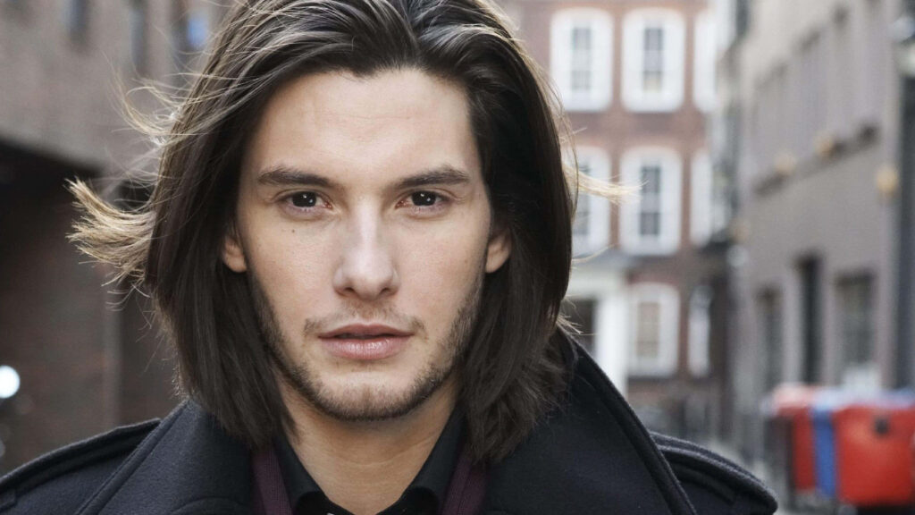 Close-up of actor Ben Barnes with long hair in urban outdoor background wallpaper image