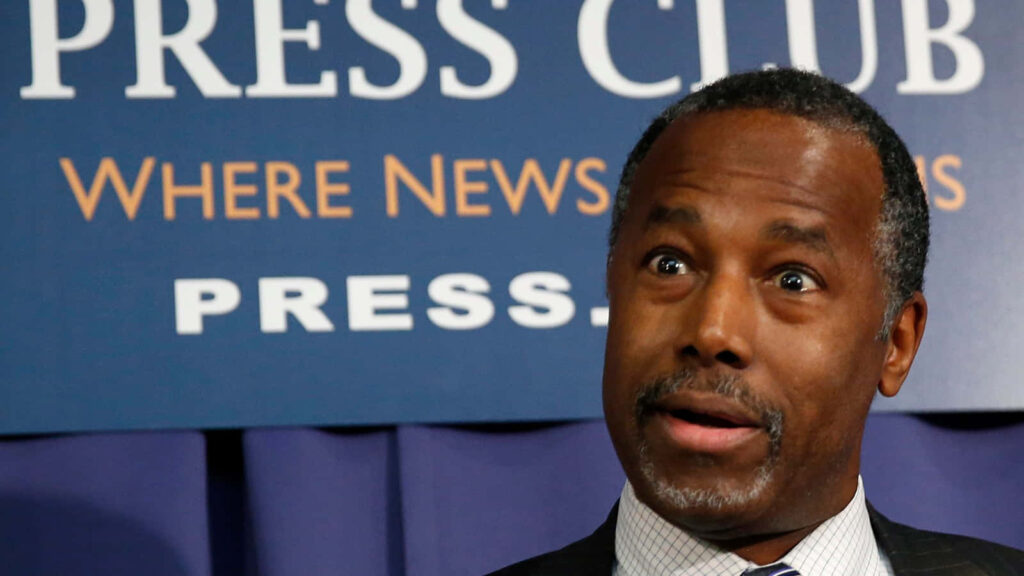 Ben Carson surprised expression at press event with Press Club backdrop journalism wallpaper