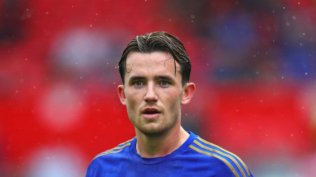 Ben Chilwell focused in football kit standing in rain with water droplets and blurred red background Wallpaper