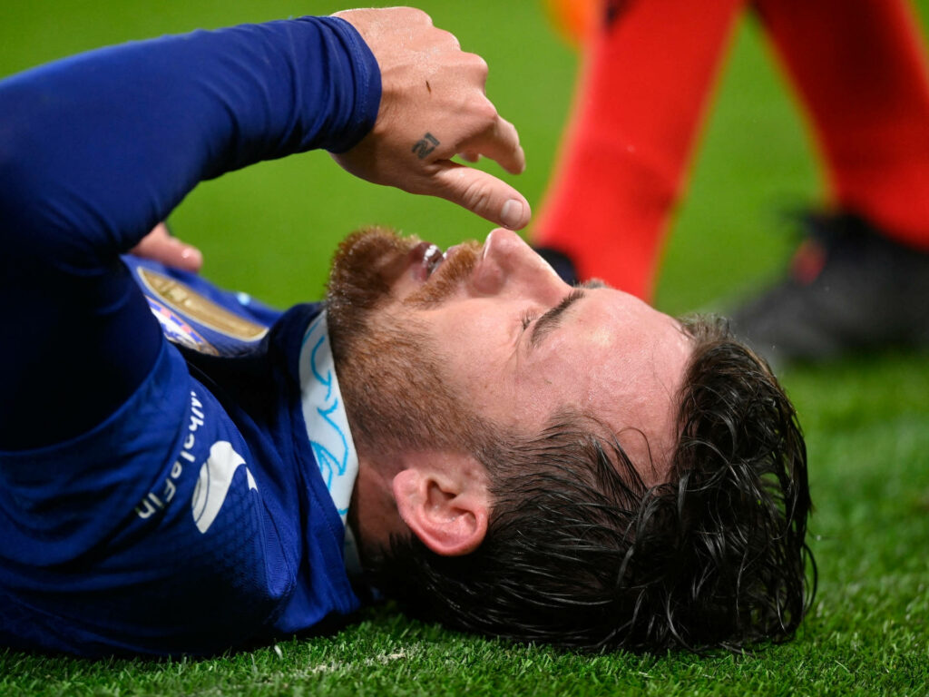 Ben Chilwell lying on football field showing intense emotion during match action wallpaper background