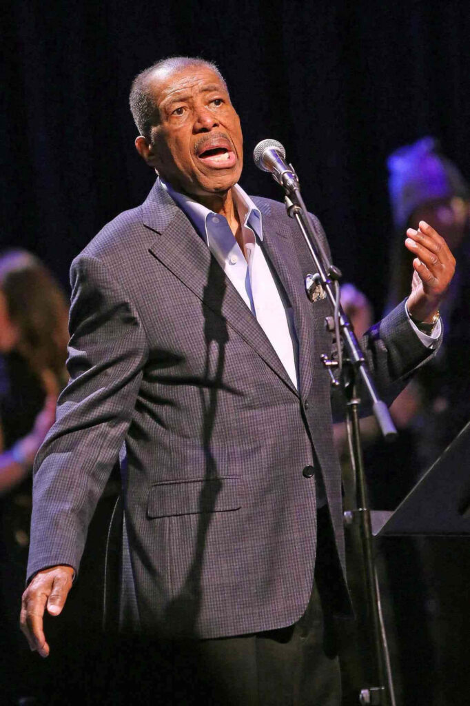 Ben E King singing passionately on stage vibrant wallpaper capturing legendary singer energy