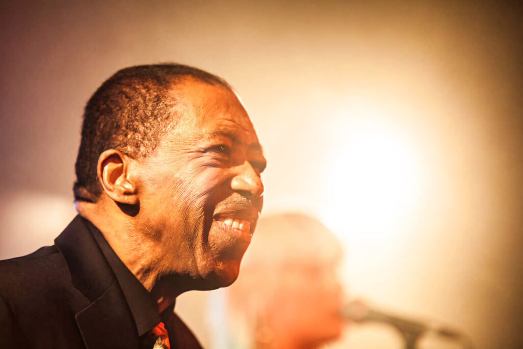 Ben E King soulful performance under warm stage lights iconic music legend wallpaper background