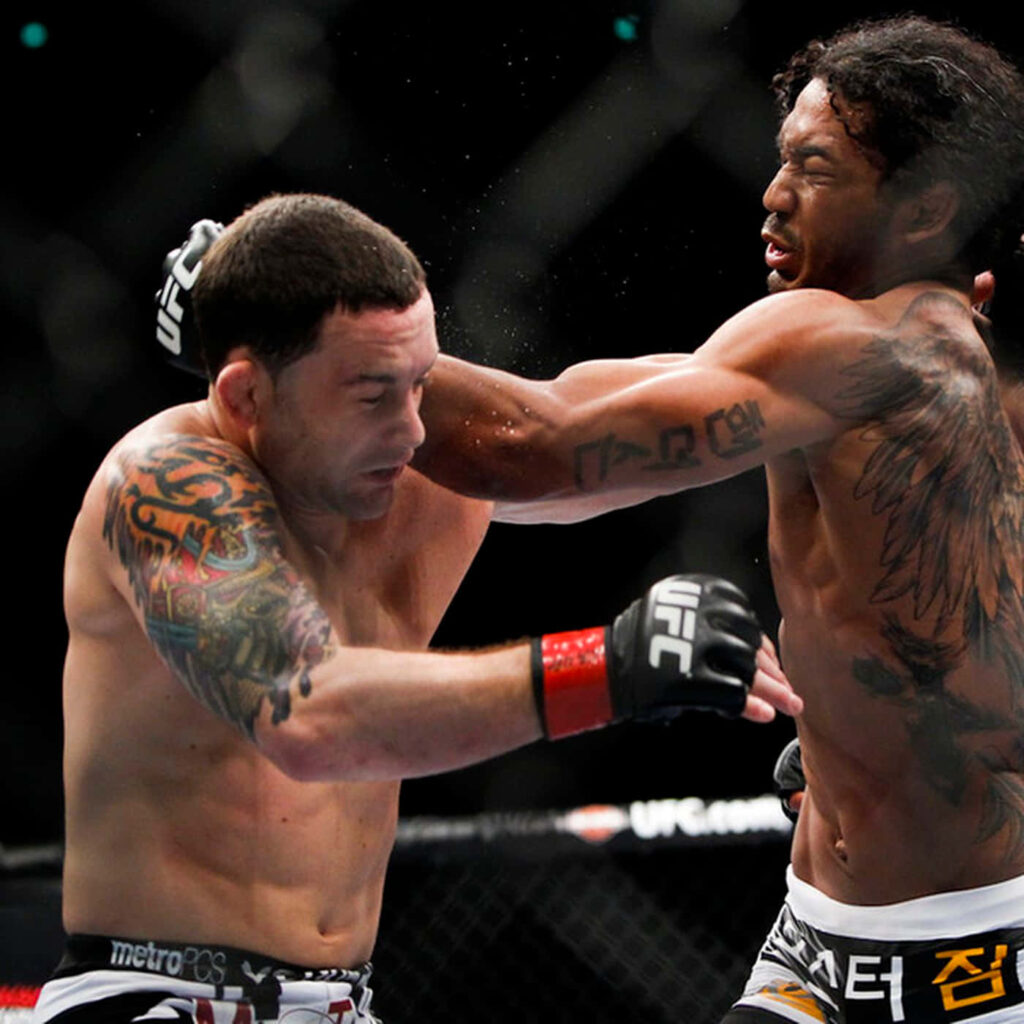 Ben Henderson and Frankie Edgar exchanging powerful punches in intense UFC octagon fight Wallpaper