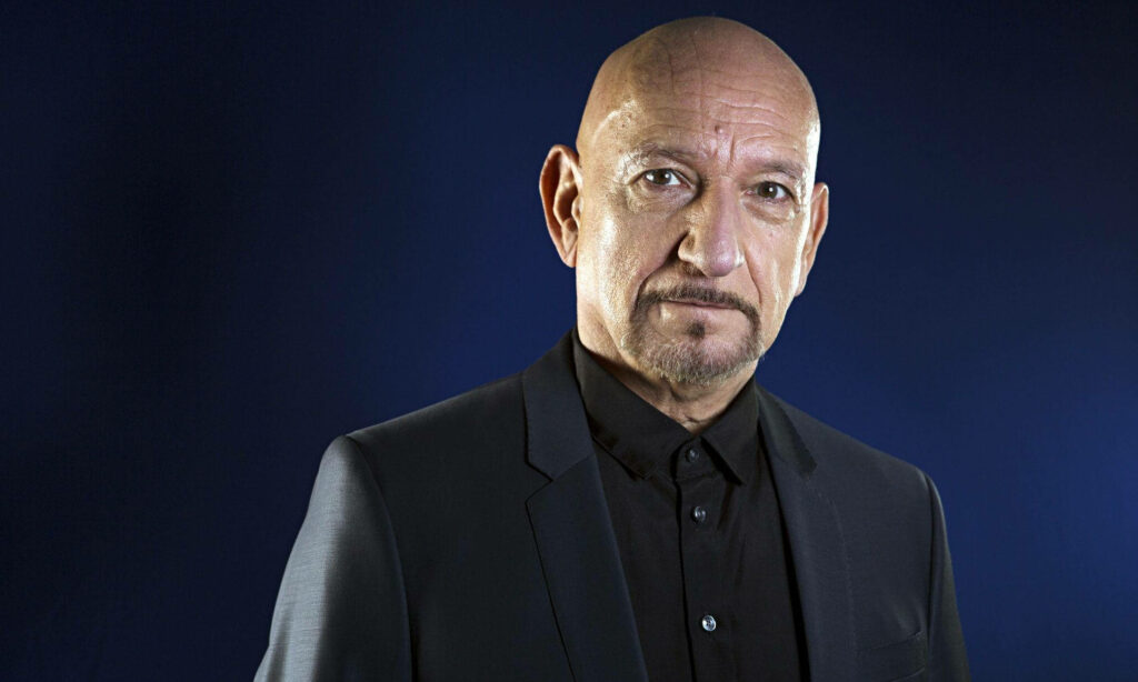 Ben Kingsley in sharp black suit pose deep blue background striking portrait The Observer UK Wallpaper