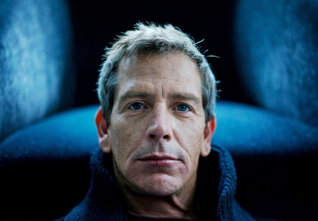 Close-up portrait of Ben Mendelsohn with intense gaze against soft blue blurred background Wallpaper