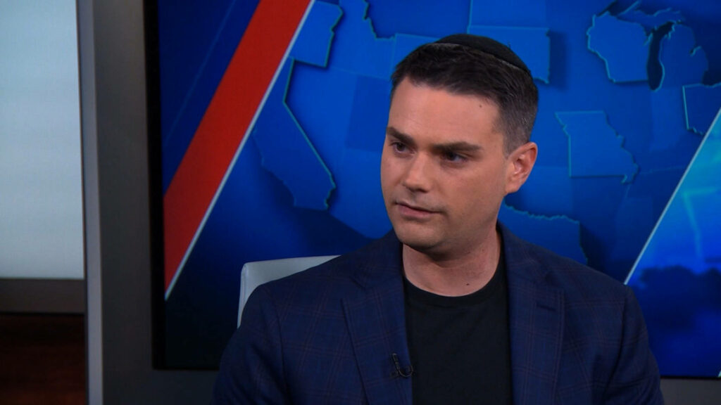 Ben Shapiro in studio with US map background wearing dark blazer and kippah professional look Wallpaper