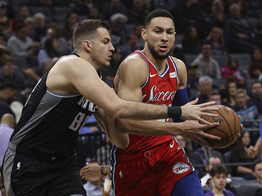 Ben Simmons showcasing strong NBA defense driving against opponent in intense basketball game wallpaper