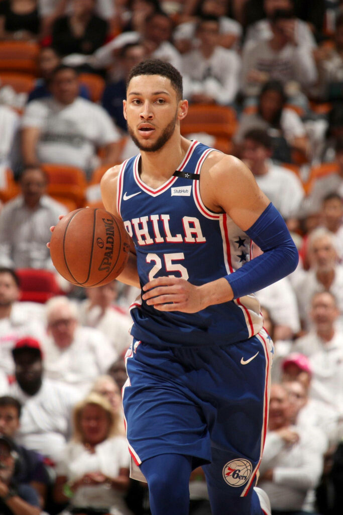Ben Simmons running down court in Philadelphia 76ers uniform during intense basketball game Wallpaper