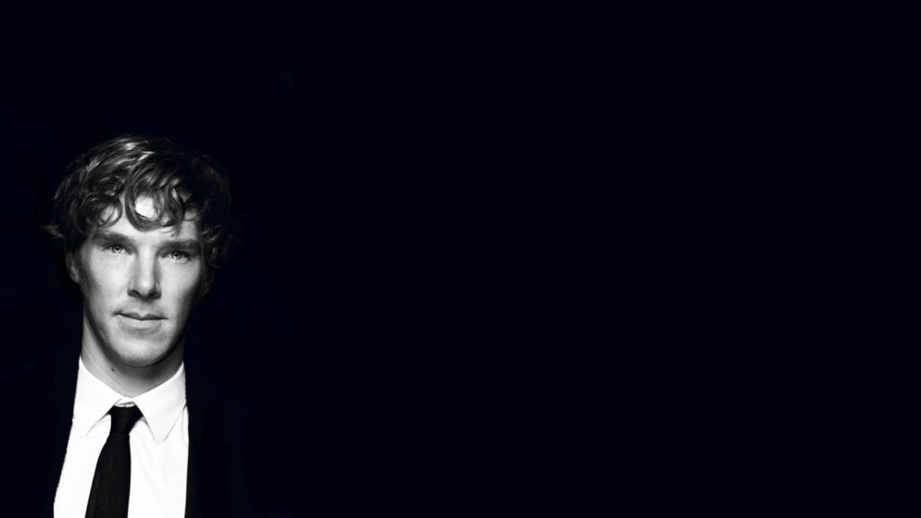 Monochrome portrait of Benedict Cumberbatch in suit on minimalistic dark wallpaper background