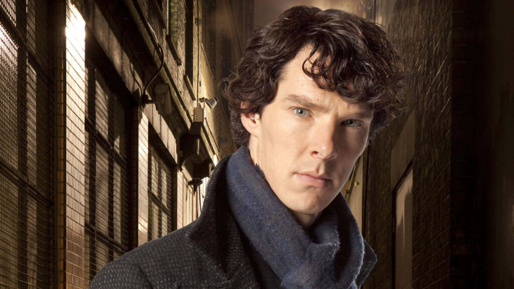 Benedict Cumberbatch as Sherlock in dark coat and scarf standing in dimly lit alleyway wallpaper