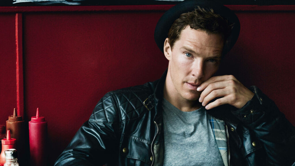 Benedict Cumberbatch in leather jacket and hat against vibrant red background wallpaper