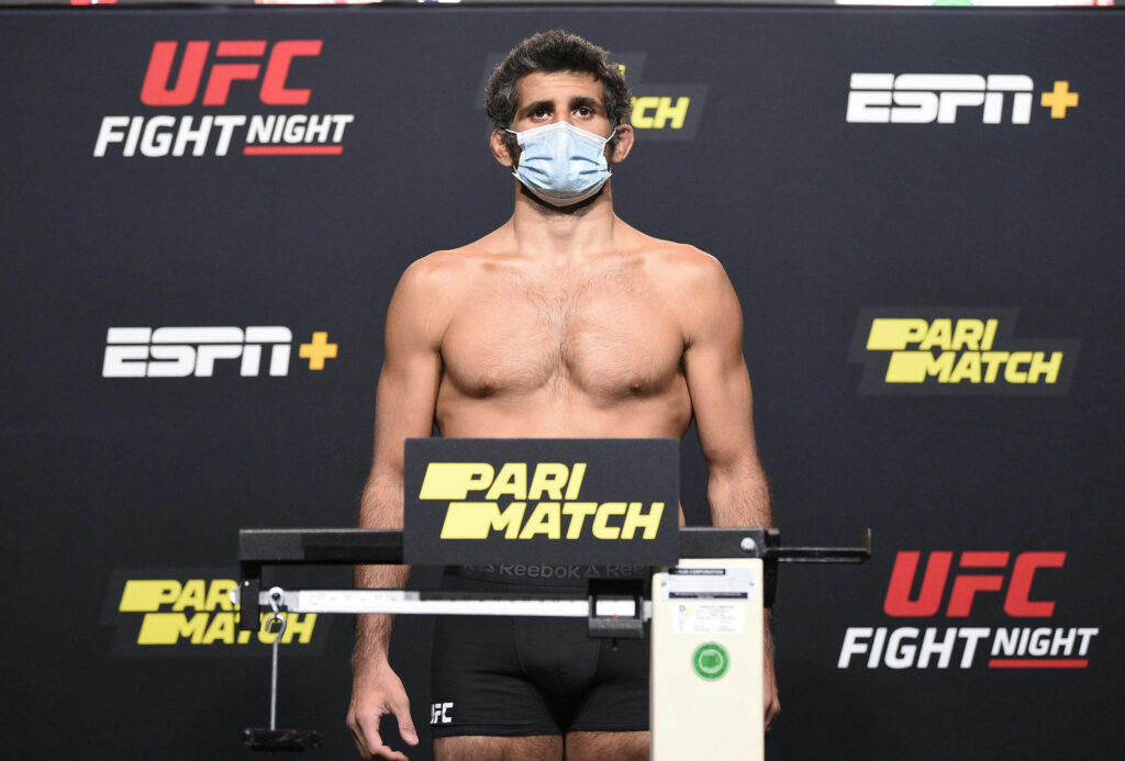 Beneil Dariush confident UFC Fight Night weigh-in wearing face mask with wallpaper background