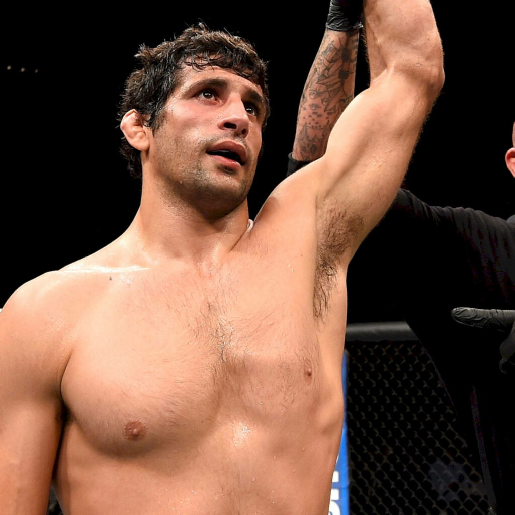 Beneil Dariush celebrating victory in the octagon after intense MMA fight with raised arm Wallpaper