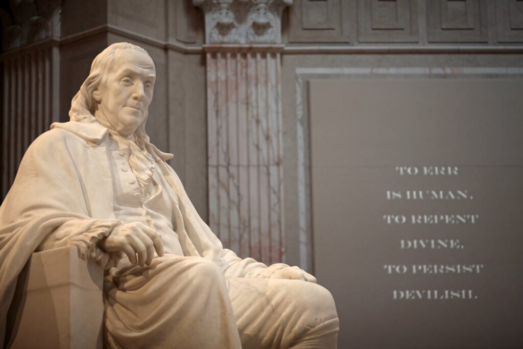 Detailed Benjamin Franklin statue with classical architecture backdrop wallpaper background