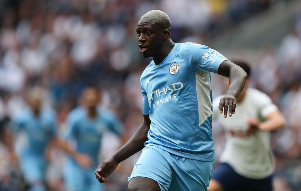 Benjamin Mendy playing football in Manchester City kit focused during intense match action Wallpaper