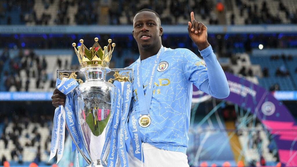 Benjamin Mendy celebrating Premier League win in Manchester City kit holding trophy on field wallpaper